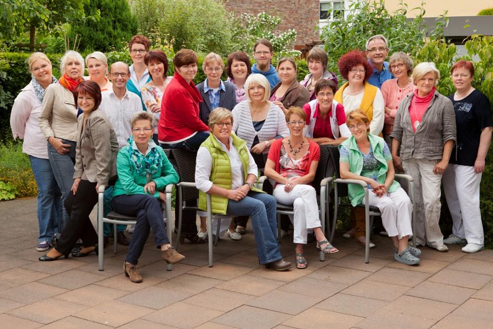 Pflegeteam bei einer gemeinsamen Gruppenaufnahme Gruppenfoto eines Pflegeteams im Garten